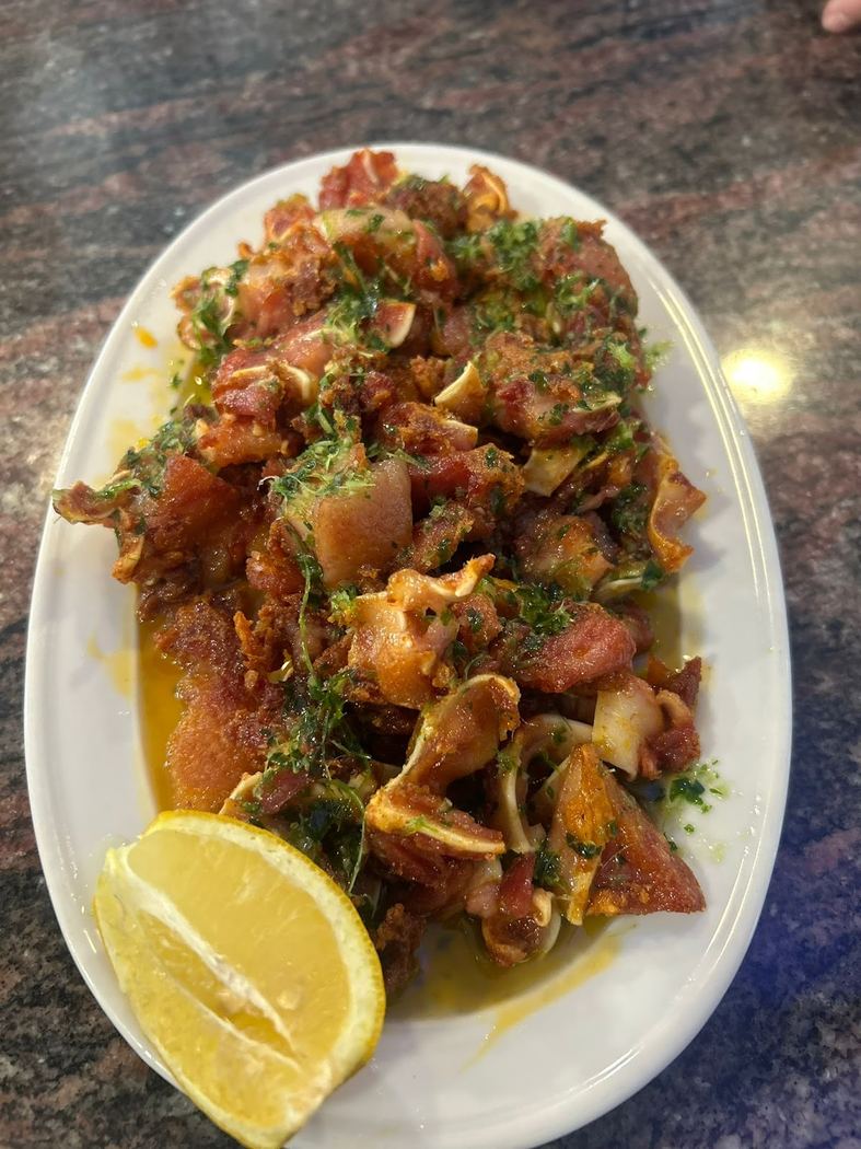 Oreja de cerdo a la plancha, crujiente y dorada, lista para compartir.